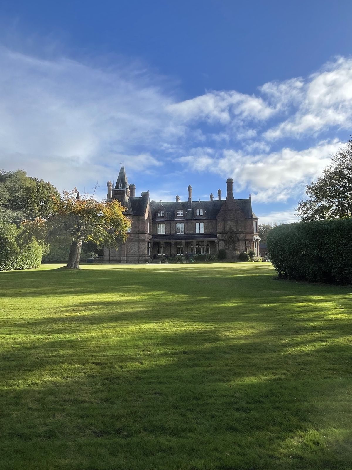 A striped lawn sweeping up to a Victorian mansion, mown by Parkside Gardening Services