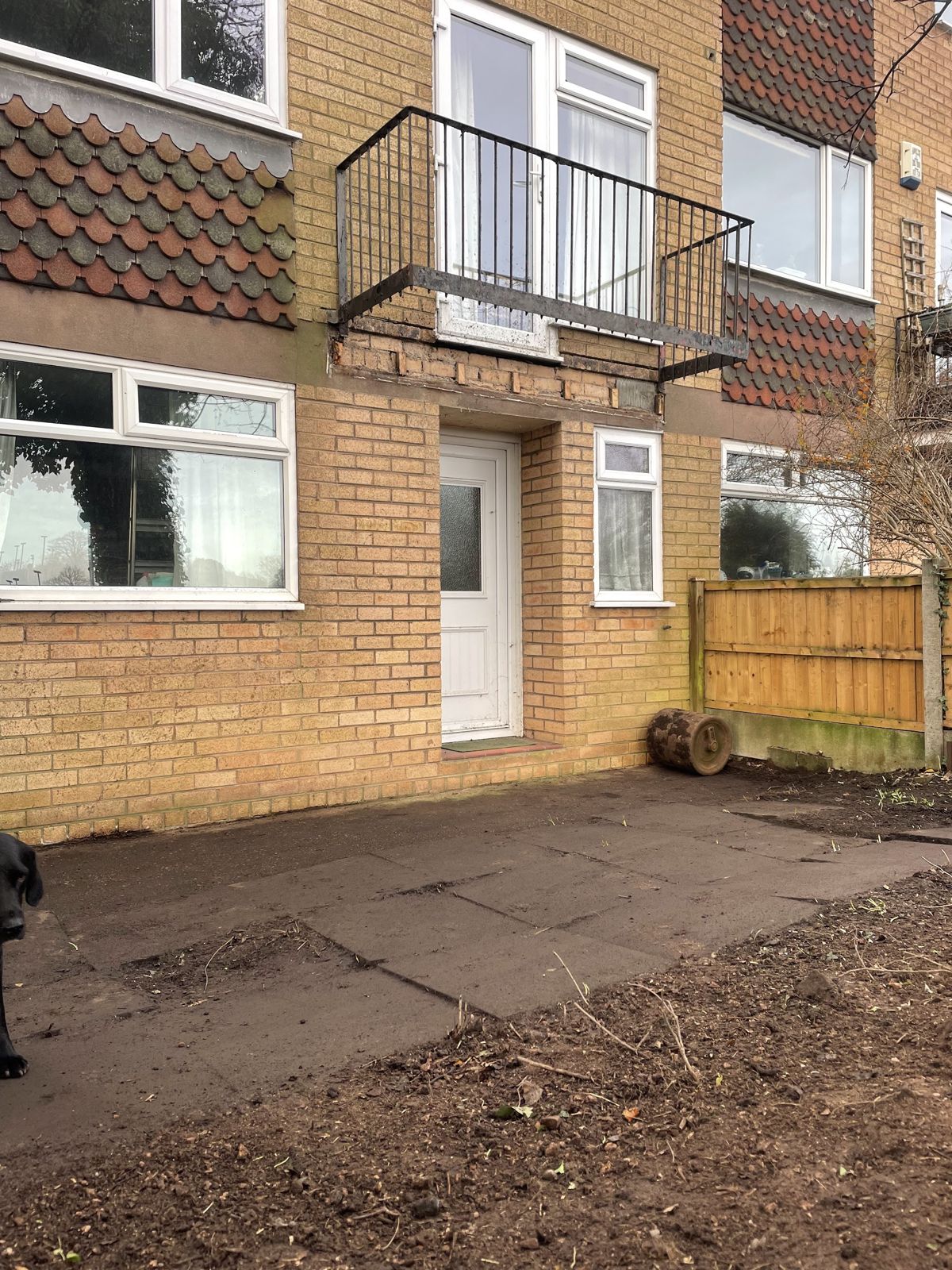 A cleared yard and bed in front of a block of flats after a clearance job